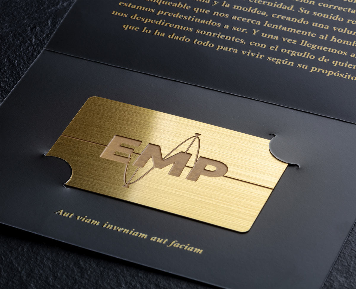 tarjeta de metal dorado con logotipo grabado y packaging premium